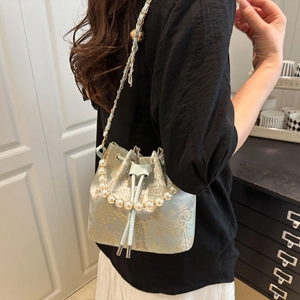 Light blue bucket bag with gold toile landscape print and elegant pearl handle