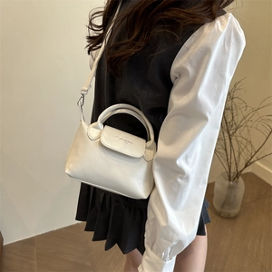 Piccola borsa a tracolla in pelle PU bianca chic indossata da una modella casual