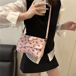 Sac bandoulière rose à motif cerises avec fond ondulé et bandoulière réglable