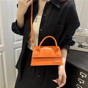 Franse stijl feloranje lederen crossbodytas met goudkleurig logo en handvat bovenaan
