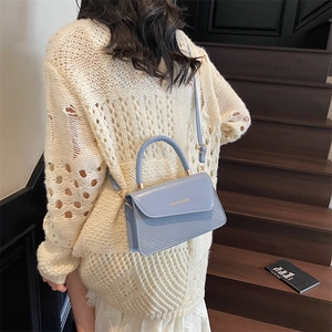 Minimalist light blue square shoulder bag with woven texture and gold hardware details