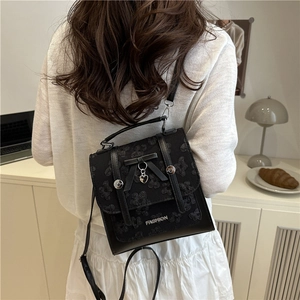 Chic black jacquard backpack for women featuring a bow design and metallic heart pendant