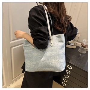 Détail du sac fourre-tout en denim bleu clair avec chaîne en perles et poignées