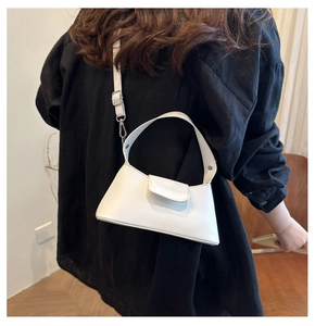 Detail of white PU leather bag with embossed logo and adjustable shoulder strap