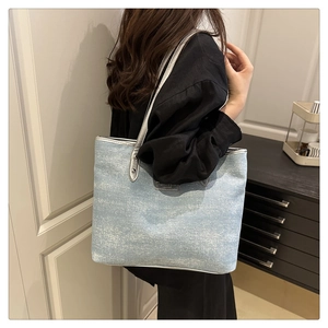 Detail of light blue tote bag with glitter texture and silver faux leather shoulder strap