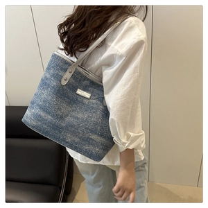 Detail of blue denim tote bag with FASHION & BAGS metal logo and sequin accents
