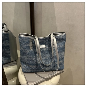 Détail du sac cabas en denim bleu scintillant avec sangles métalliques et plaque de mode