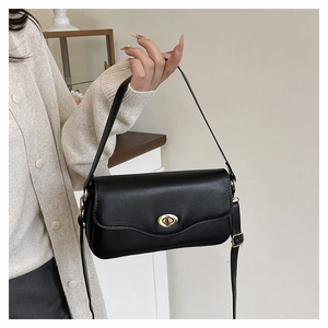 Detailaufnahme der schwarzen PU-Lederhandtasche mit goldenem Drehverschluss und Schultergurt