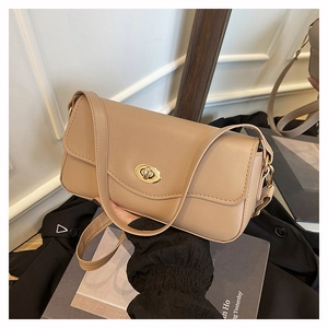 Detail der beigen Leder-Schultertasche mit einem polierten goldenen Oval-Drehverschluss