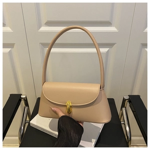 Detail of minimalist beige leather baguette bag with a premium golden oval metal clasp