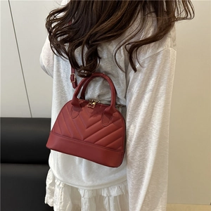 Chic red quilted shell-shaped crossbody bag with gold hardware and stylish V-pattern stitch