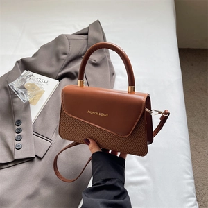 Close-up of retro brown contrast stitching handbag with gold foil lettering detail