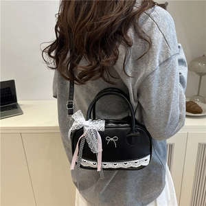 Black shell crossbody bag with metal bow and lace heart trim for summer fashion