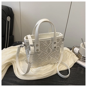 Detail of white tote bag featuring grey geometric jacquard and silver hardware accents