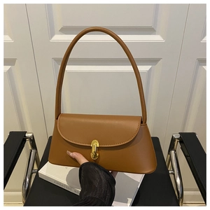 Detail of caramel brown matte leather shoulder bag with golden metallic buckle closure