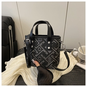 Detail of mini tote bag with silver geometric embroidery and black leather straps