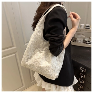 Detailed look at the white floral lace texture on a large capacity shoulder tote bag