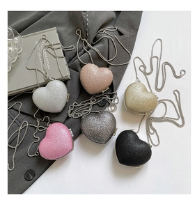 Detailed flat lay of heart-shaped glitter mini bags in six stylish colors with chain straps