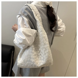 Detailed close-up of white mesh tote bag with 3D floral embroidery and lace texture
