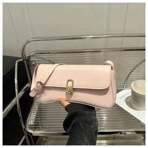 Détail du sac baguette rose avec boucle dorée sur un présentoir de rangement