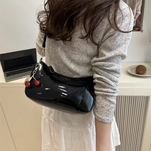 Glossy black patent leather crescent shoulder bag with cherry charm and fashion logo