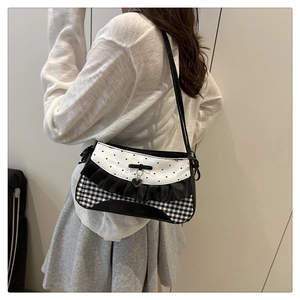 Detail of a sweet bow shoulder bag with heart patterns, ruffles, and chic plaid fabric