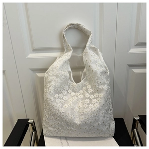 Close-up of floral embroidery lace fabric on a white hobo bag with aesthetic bow detail