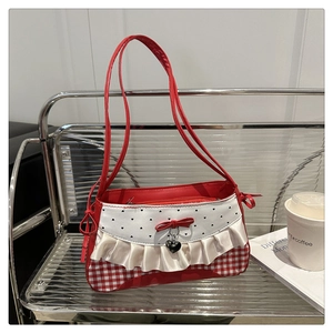 Detail of red and white plaid shoulder bag featuring lace trim and a bow accent