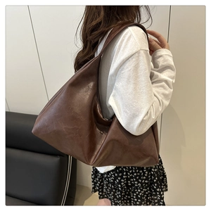 Detail view of deep brown oversized hobo tote bag in premium faux leather texture
