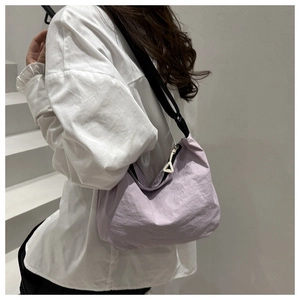Detail of light purple nylon crossbody bag with pleated texture and black strap