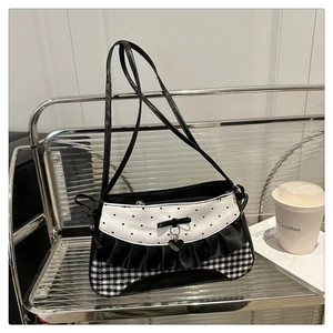 Detail of sweet heart pattern handbag with bow pendant and black satin ruffle trim