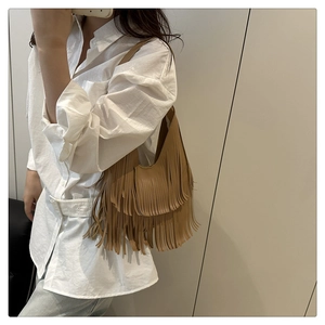 Detailansicht einer braunen Fransentasche im Boho-Stil mit weichem Leder und Schultergurt