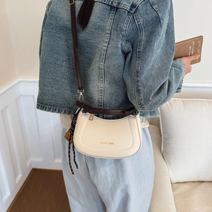 Fashionable cream half-moon crossbody bag with dark brown strap and zipper detail