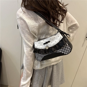 Stylish black and white checkered shoulder bag with ruffle trim and heart pendant