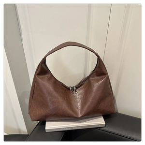 Detail view of large dark brown retro shoulder bag with smooth wax leather texture