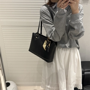 Chic black leather tote bag with a decorative printed scarf and long shoulder straps