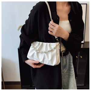Détail du sac plissé blanc avec chaîne de perles élégante et fine bandoulière réglable