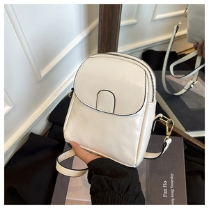 Détail du sac à bandoulière en cuir blanc cassé avec ferrures dorées et rabat magnétique