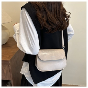 Detail van beige minimalistische crossbodytas met Ranvissa-logo gedragen door een model
