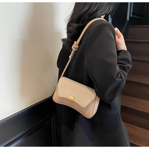 Détail du sac bandoulière champagne avec texture pailletée et boucle dorée carrée chic