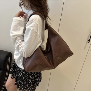 Minimalist large brown hobo shoulder bag for women in soft leather on model