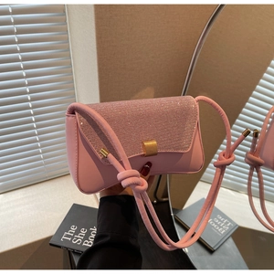 Gros plan du sac rose avec rabat en strass scintillant et boucle dorée élégante