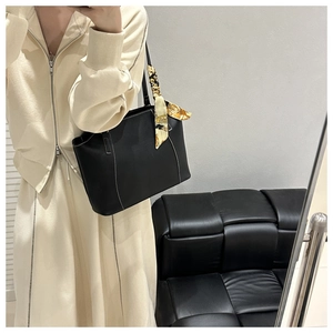 Détail du sac cabas en cuir noir avec surpiqûres blanches et foulard en soie imprimé