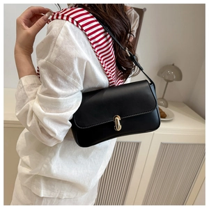 Classic black leather underarm bag with gold twist lock shown on model with white top