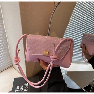 Gros plan d'un sac à bandoulière rose avec rabat en strass et détail de bandoulière nouée