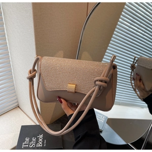 Détail du sac bandoulière nude avec rabat en strass, boucle dorée et bandoulière nouée