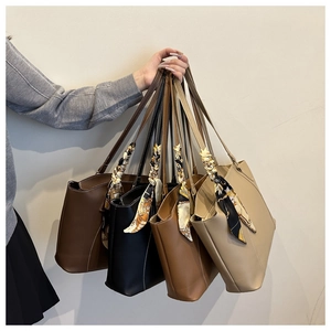 Détail de grands sacs fourre-tout en quatre couleurs avec des foulards en soie décoratifs