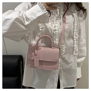 Détail de sac à bandoulière rose avec texture mesh et étiquette de mode élégante
