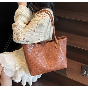 Détail montrant la texture en cuir tressé marron de ce grand sac fourre-tout