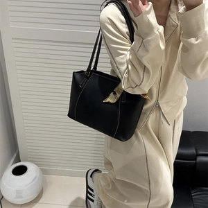 Sac fourre-tout noir minimaliste avec coutures blanches et foulard sur mannequin